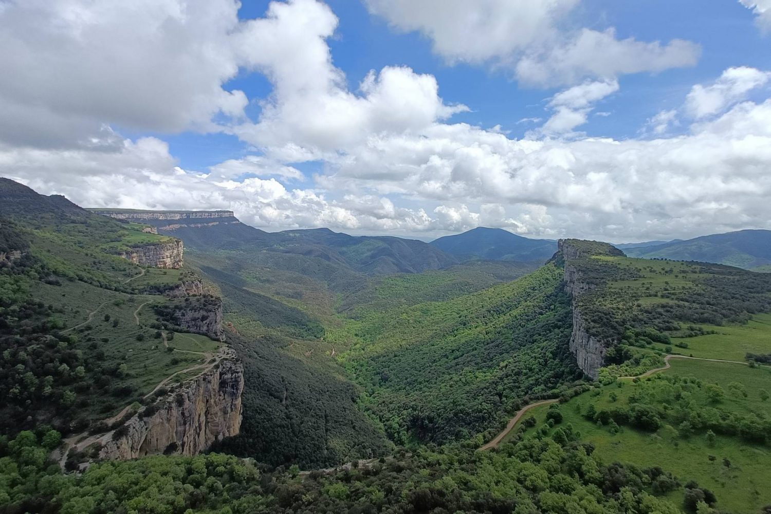 Vista panoràmica d’una vall verda envoltada de cingleres.